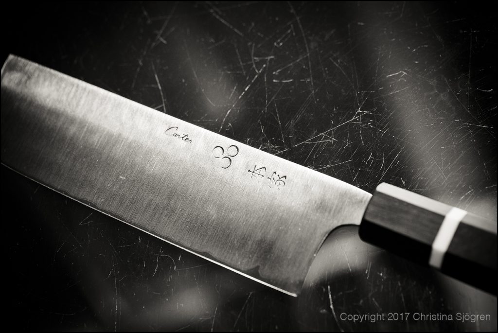 A Japanese type of kitchen knife with a high carbon steel core laminated with a soft outer steel made by Murray Carter, 17th generation Yoshimoto Bladesmith, Portland, Oregon, USA